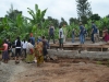 Workers, volunteers, and kids helping to pour and level the cement for the foundation!
